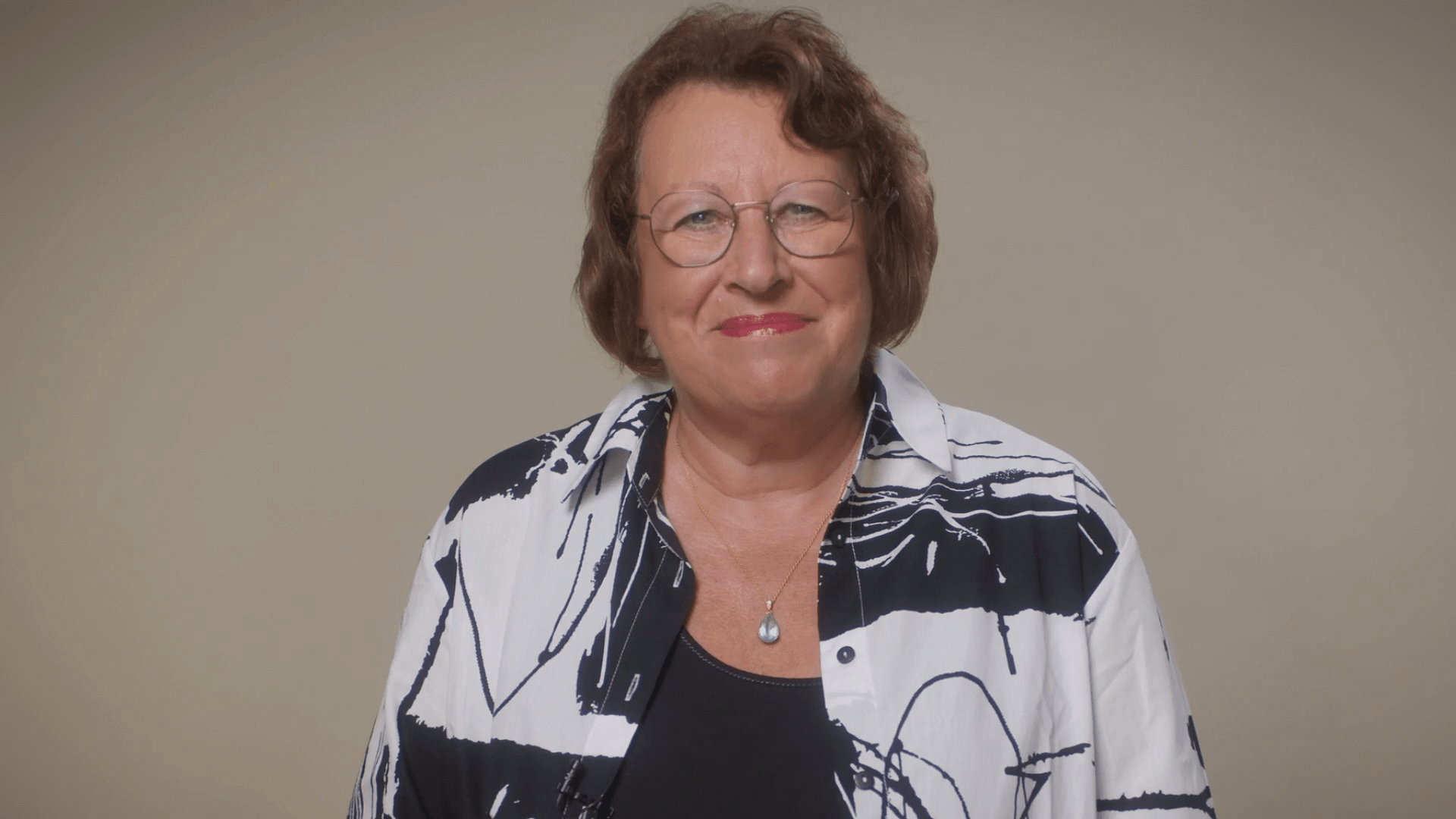 Professional woman smiling at camera in corporate video still frame