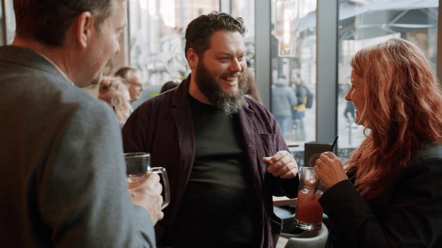 Business people smiling and chatting at networking event held by Business Introductions
